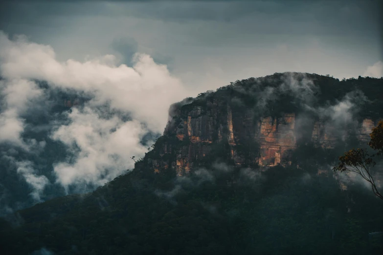 a mountain with clouds rising over it