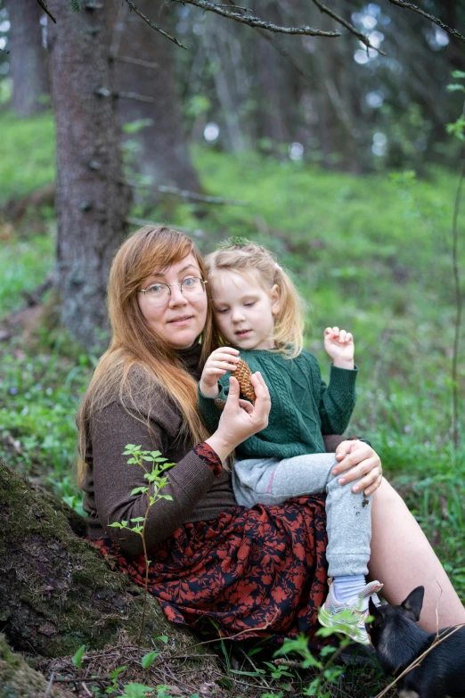 the woman is holding the little girl on her lap