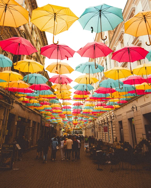 many umbrellas hanging above a city street