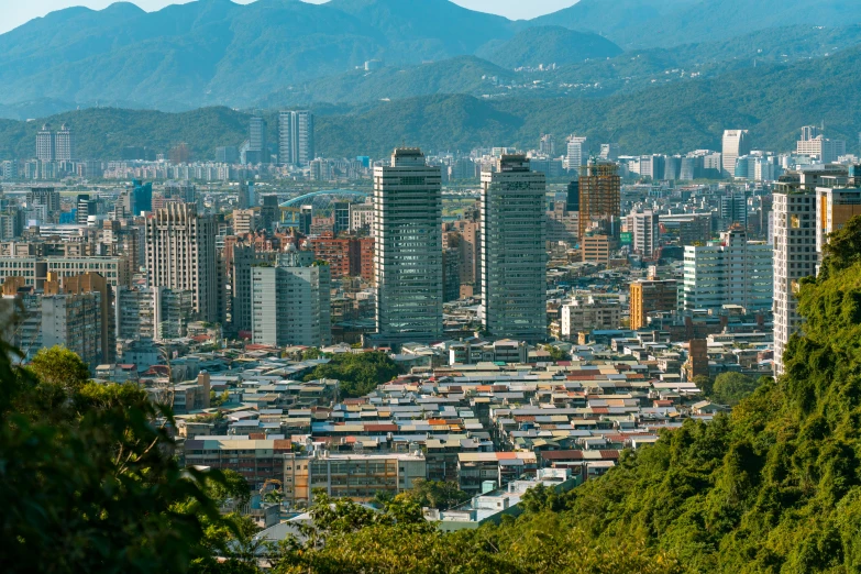 a city with skyscrs in the foreground, and mountains in the background