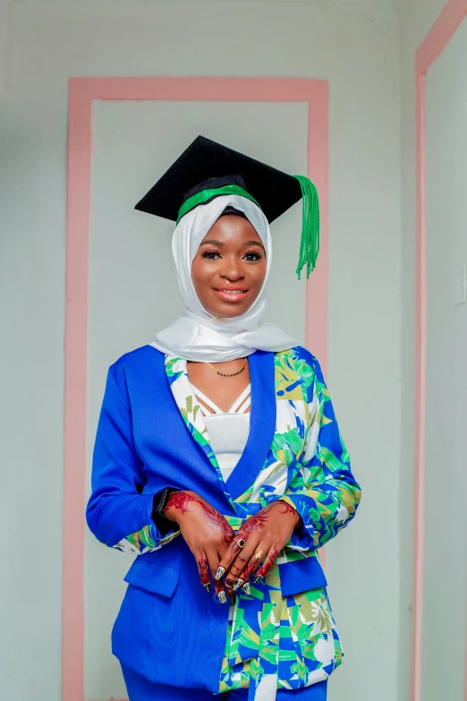 a beautiful woman wearing a blue suit and a graduation hat