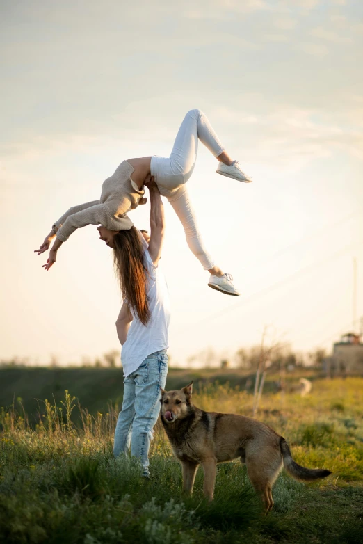 woman balancing on hands and holding up the other girl