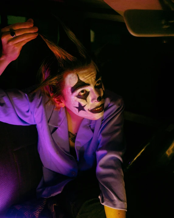 a clown dressed up and sitting inside a car