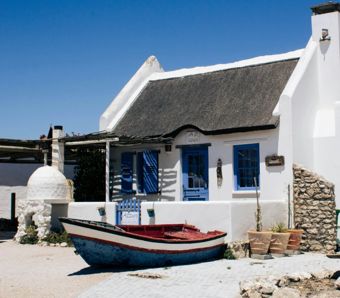 an old, dilapidated boat rests next to a modern house