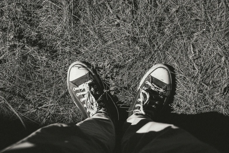 person wearing tennis shoes in a field of tall grass