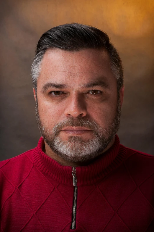 man in red sweater posing for a studio po