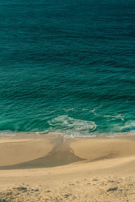 an empty beach with water on the horizon