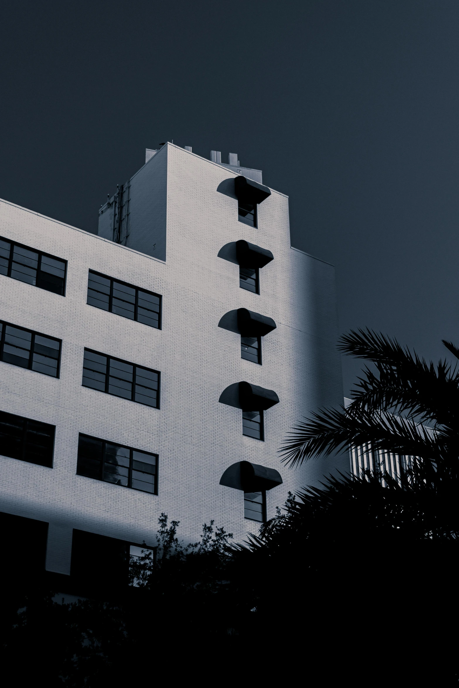 a very tall white building sitting under a dark sky