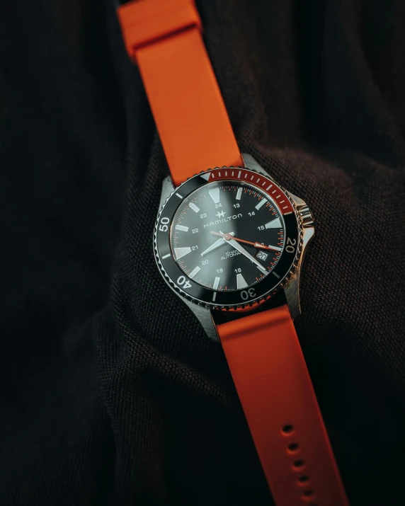 a watch with a red face and orange strap