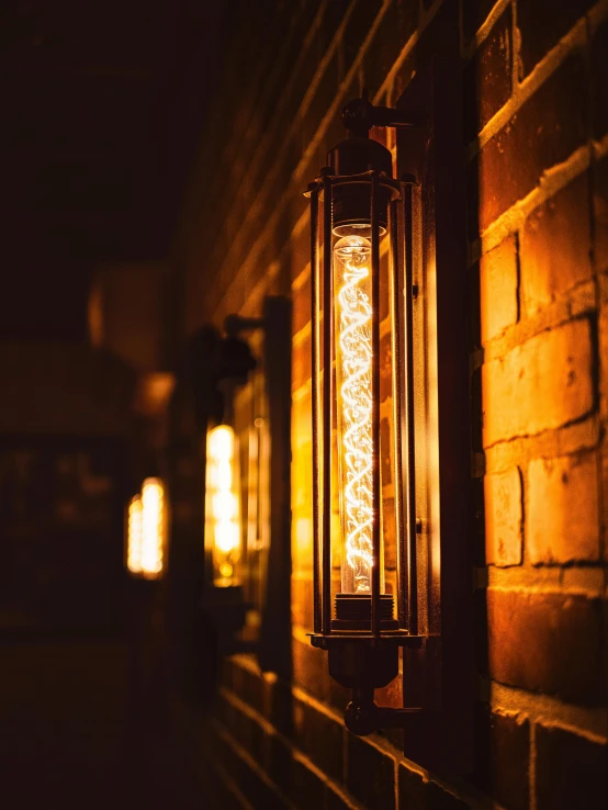 a lit lantern next to a wall at night