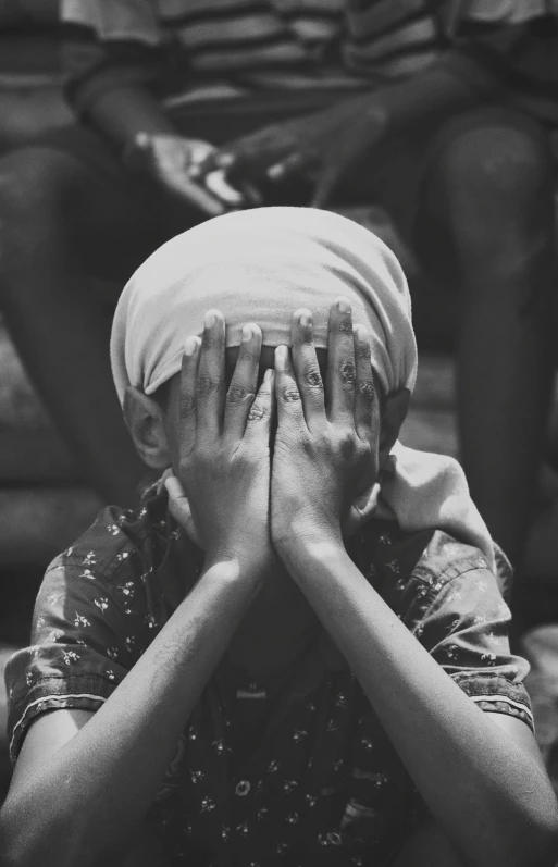 a man covering his face with a cloth over his head