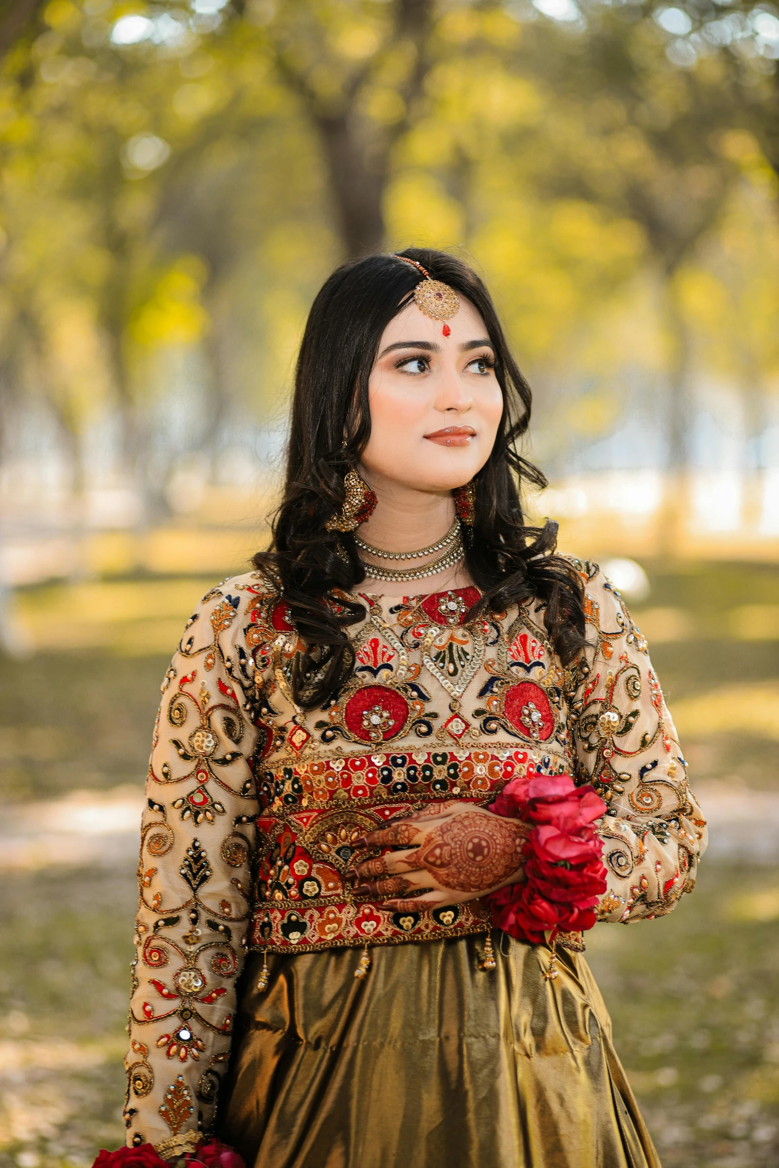 a young woman standing in a park wearing red rose accessories