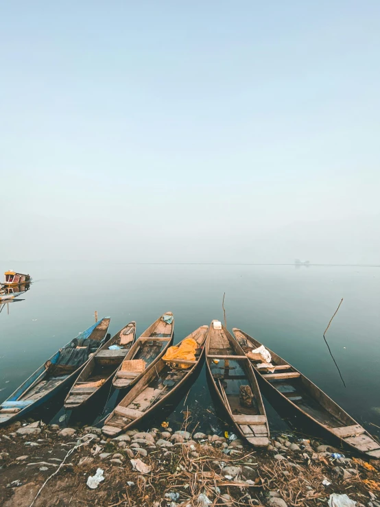 boats sitting on top of a pile of debris in the water