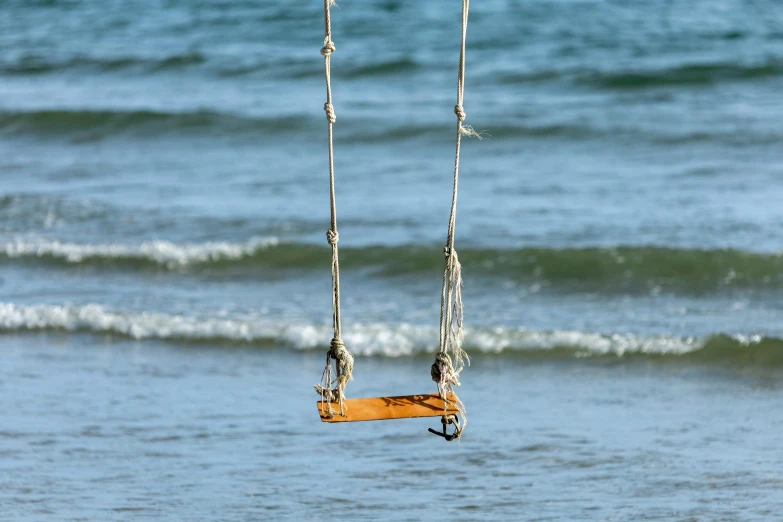 a pair of orange board hanging on a line in the water