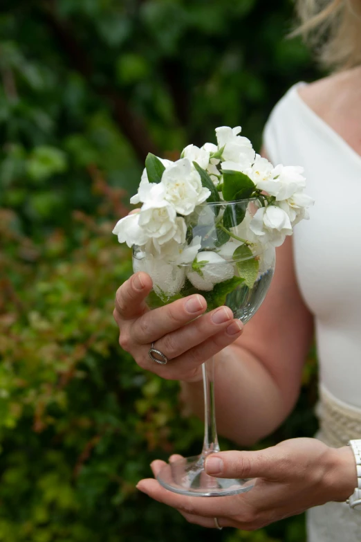 there is a woman holding some flowers in her hand