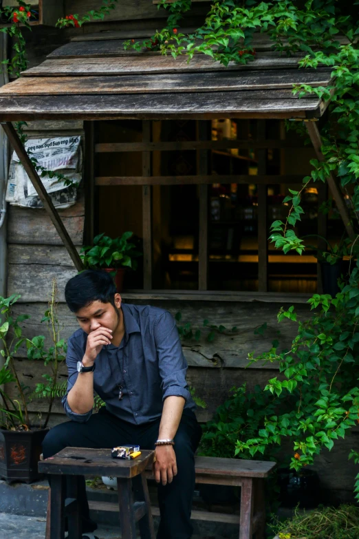 a man sitting at a picnic table with his hands to his face