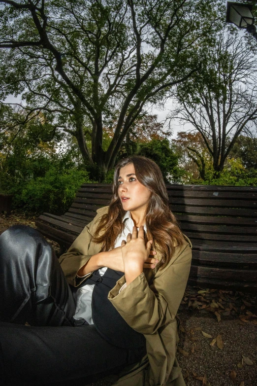 a girl in brown jacket on bench posing for picture