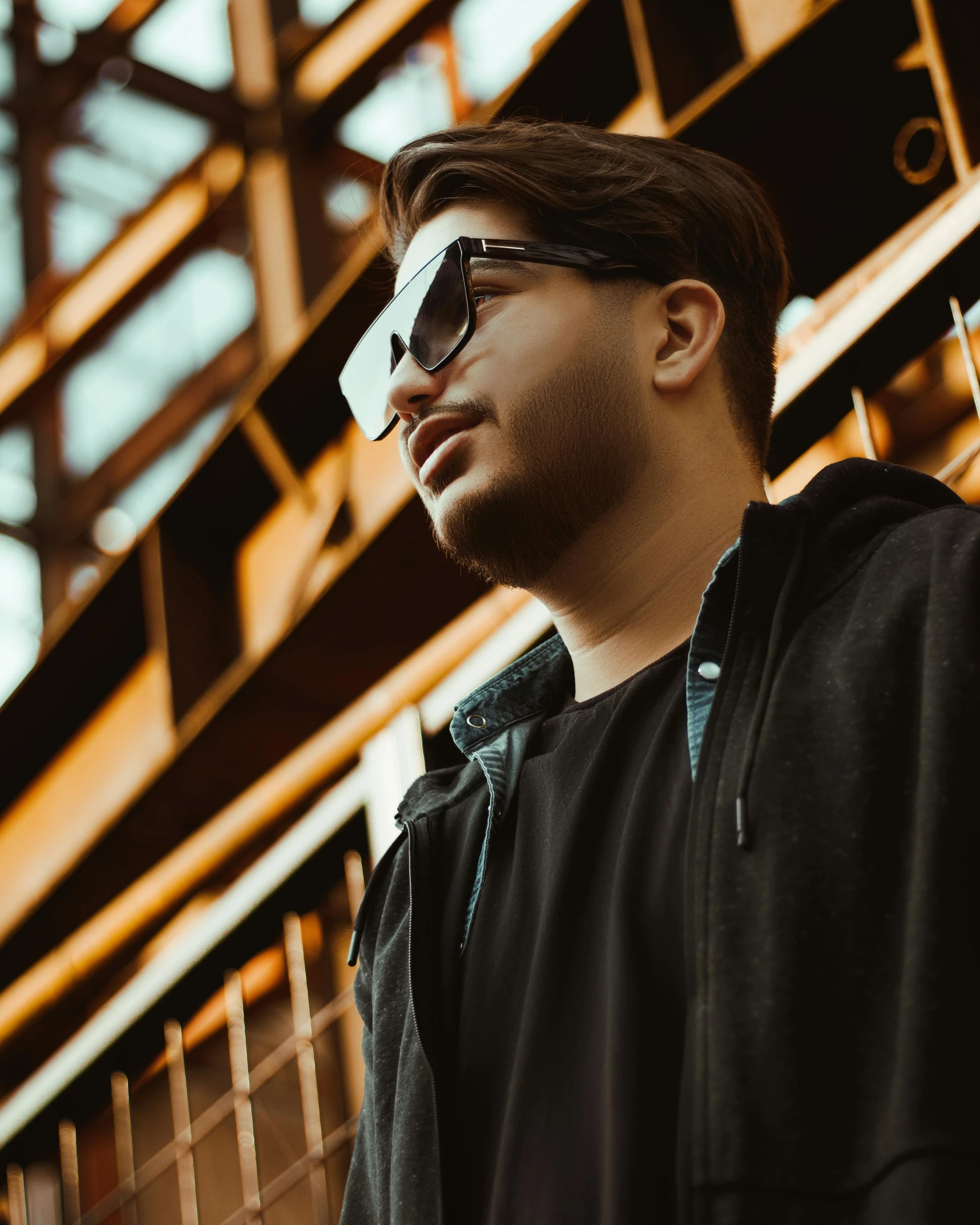 a man standing in front of some stairs and wearing sunglasses