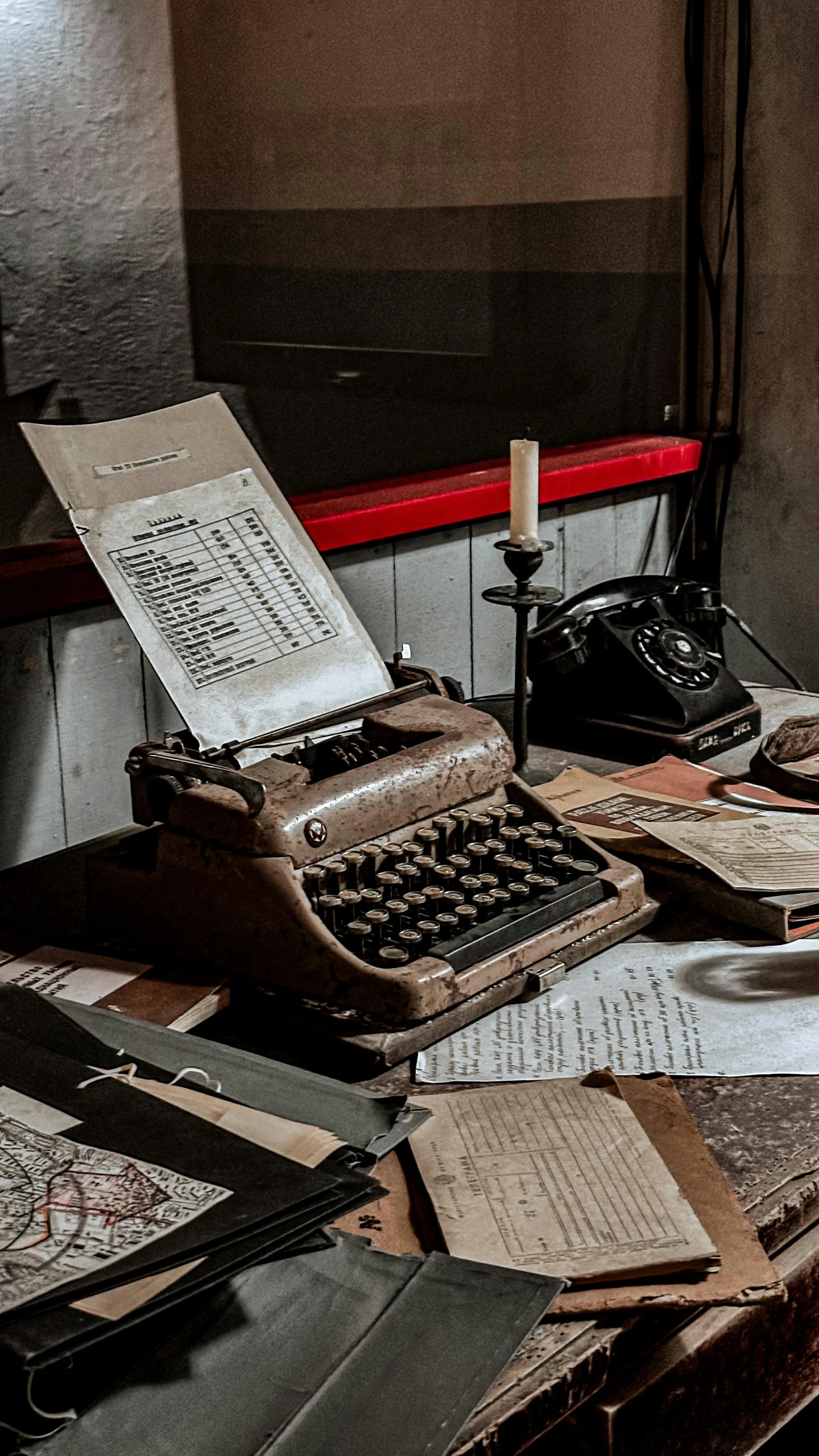 old papers, an antique typewriter and other items are on the desk