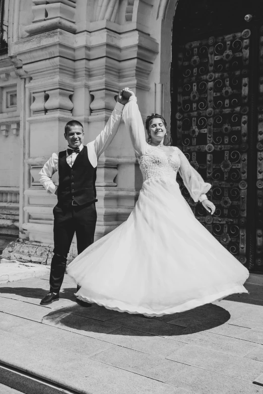 a bride and groom standing on a sidewalk