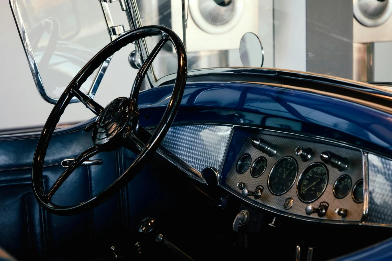 an old blue car with many gauges, steering wheel and dash board