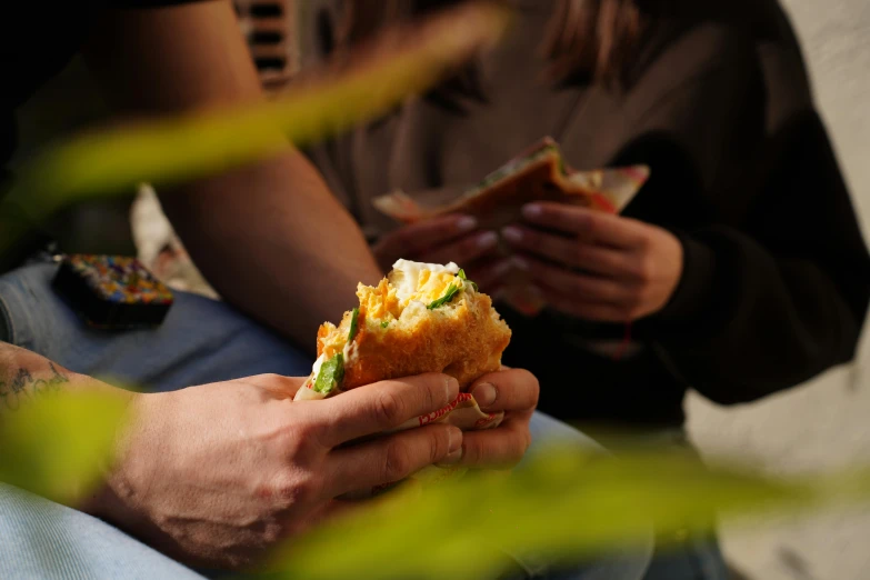 someone eating a sandwich while sitting on a couch