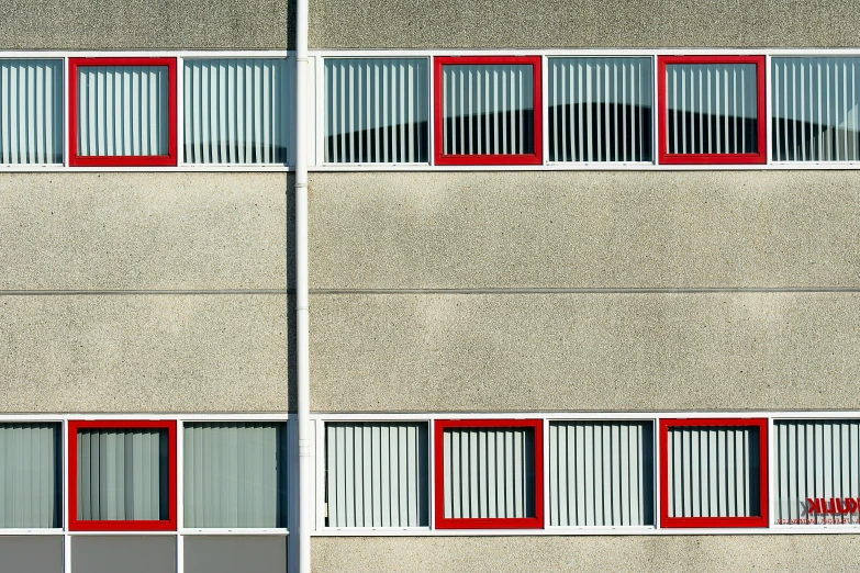 a red window on the side of a building with bars on both sides