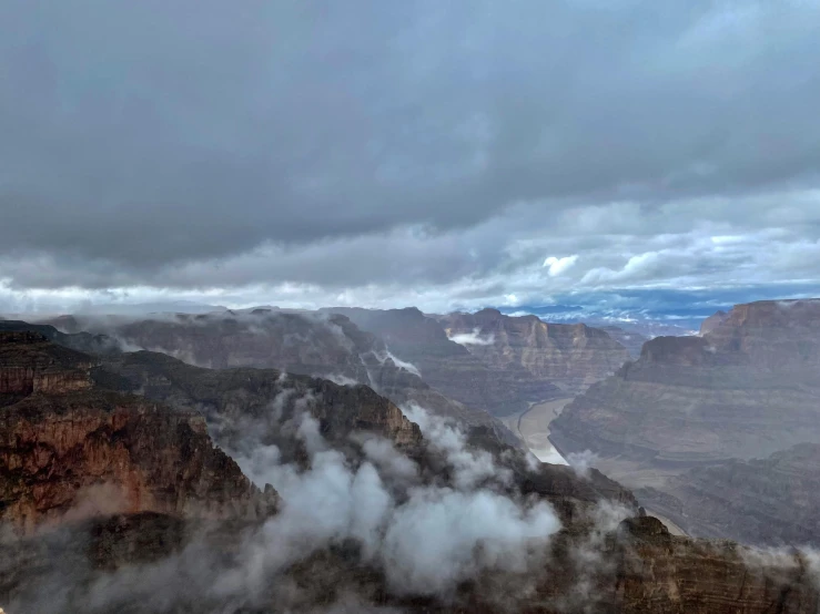 view of some mountains with clouds above