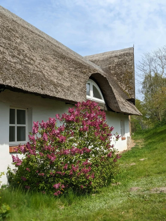 a white cottage with flowers in front