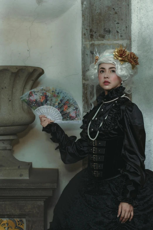 a beautiful young woman in a black dress with white hair holding a white paper fan