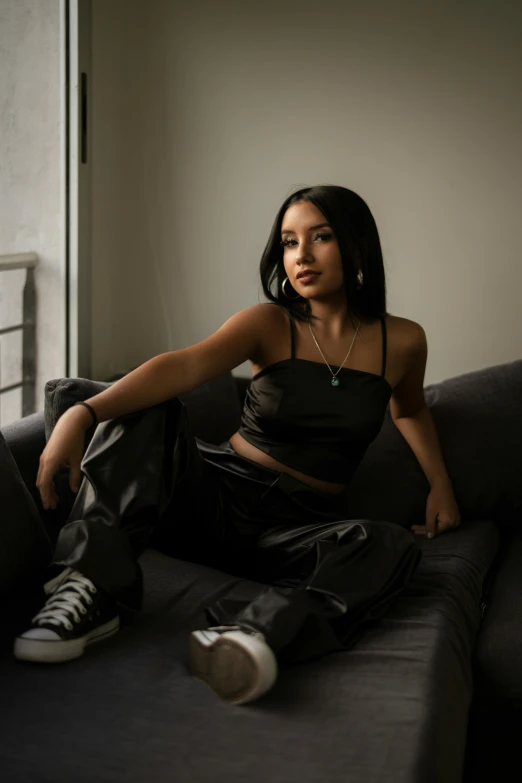 a woman sits in front of a couch while looking off into the distance