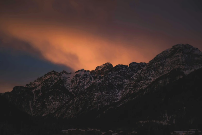 the clouds are coming off of the top of the mountain