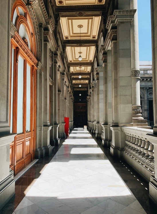 a walkway with wooden doors and railings leads to an upper level