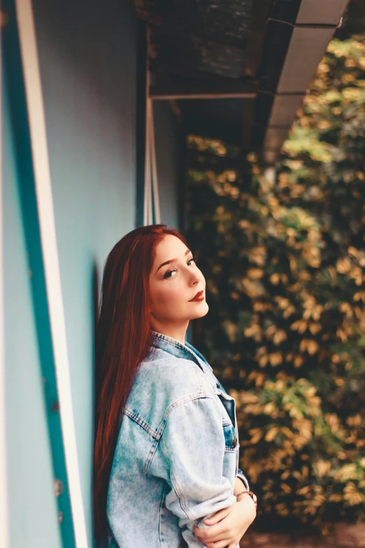 a woman standing by the side of a building