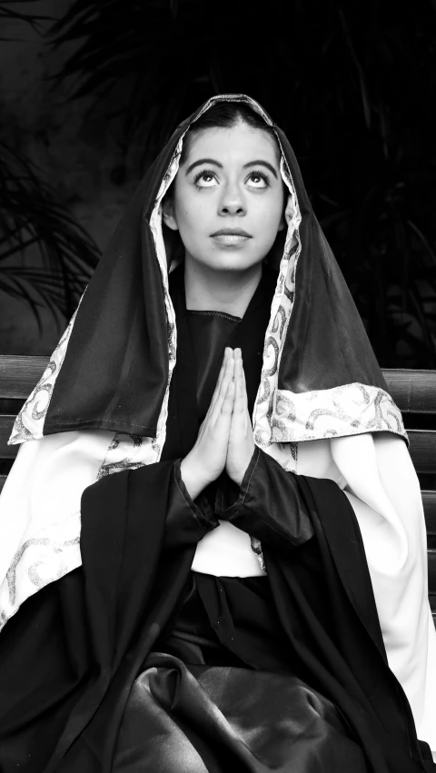 a woman with her hands folded at the bottom of her head while sitting on steps