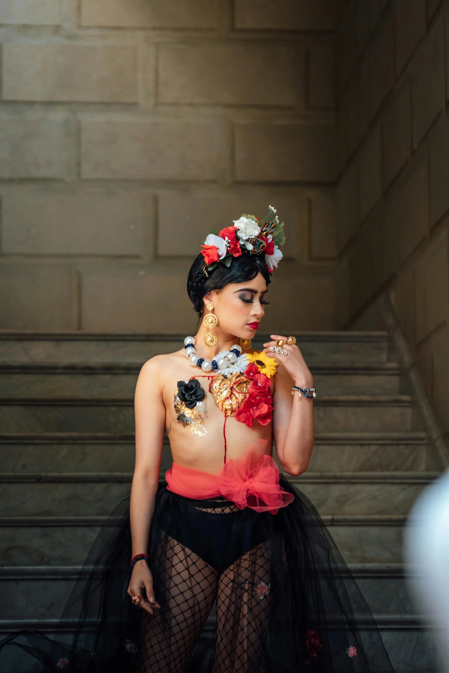 a person wearing a sheer skirt and colorful headpiece