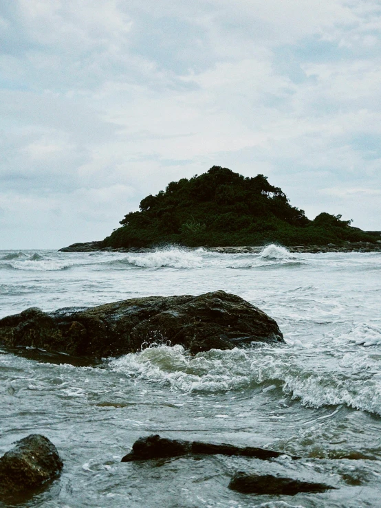 a large rock near the shore of the ocean