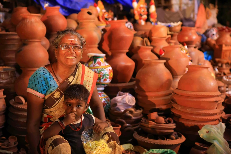 a woman and her child are in a display of clay pots