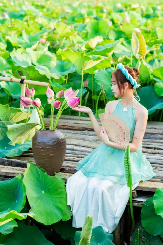 a woman holding a plant in a large garden