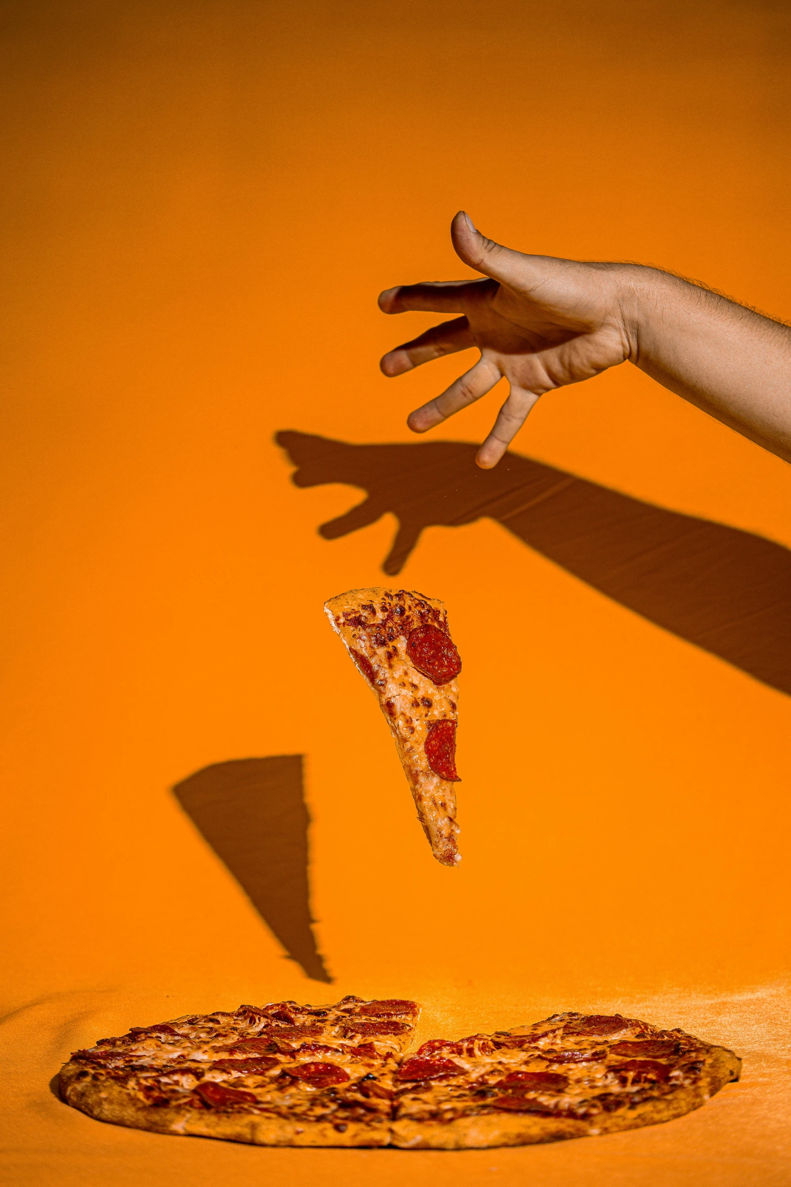 hand coming off of pizza near a slice missing