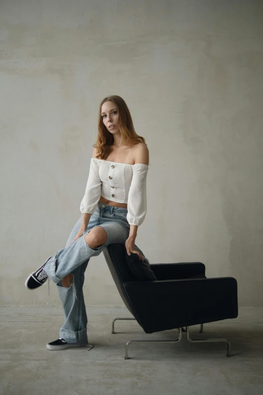 a young woman is sitting on a chair