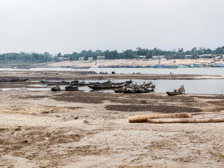 a beach with several canoes resting on the beach