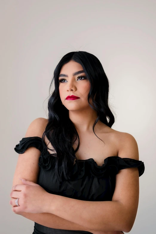 an attractive young woman with her arms folded while posing for a portrait