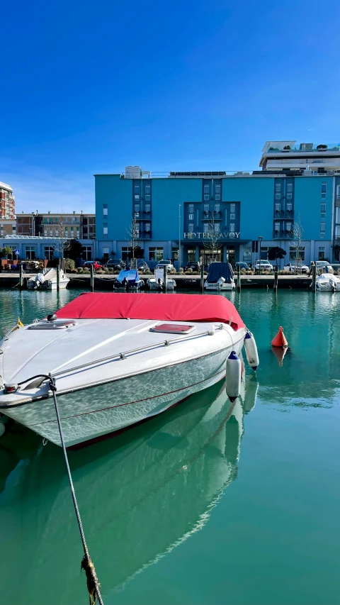 a small boat sitting on top of a harbor next to buildings