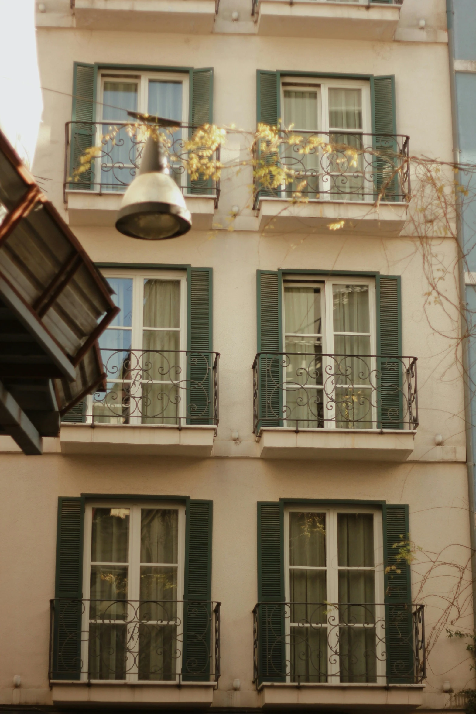 a very tall building with green shutters and windows