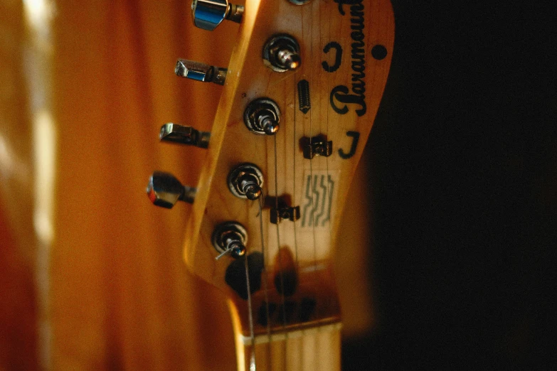 an old and worn guitar, showing the tuners