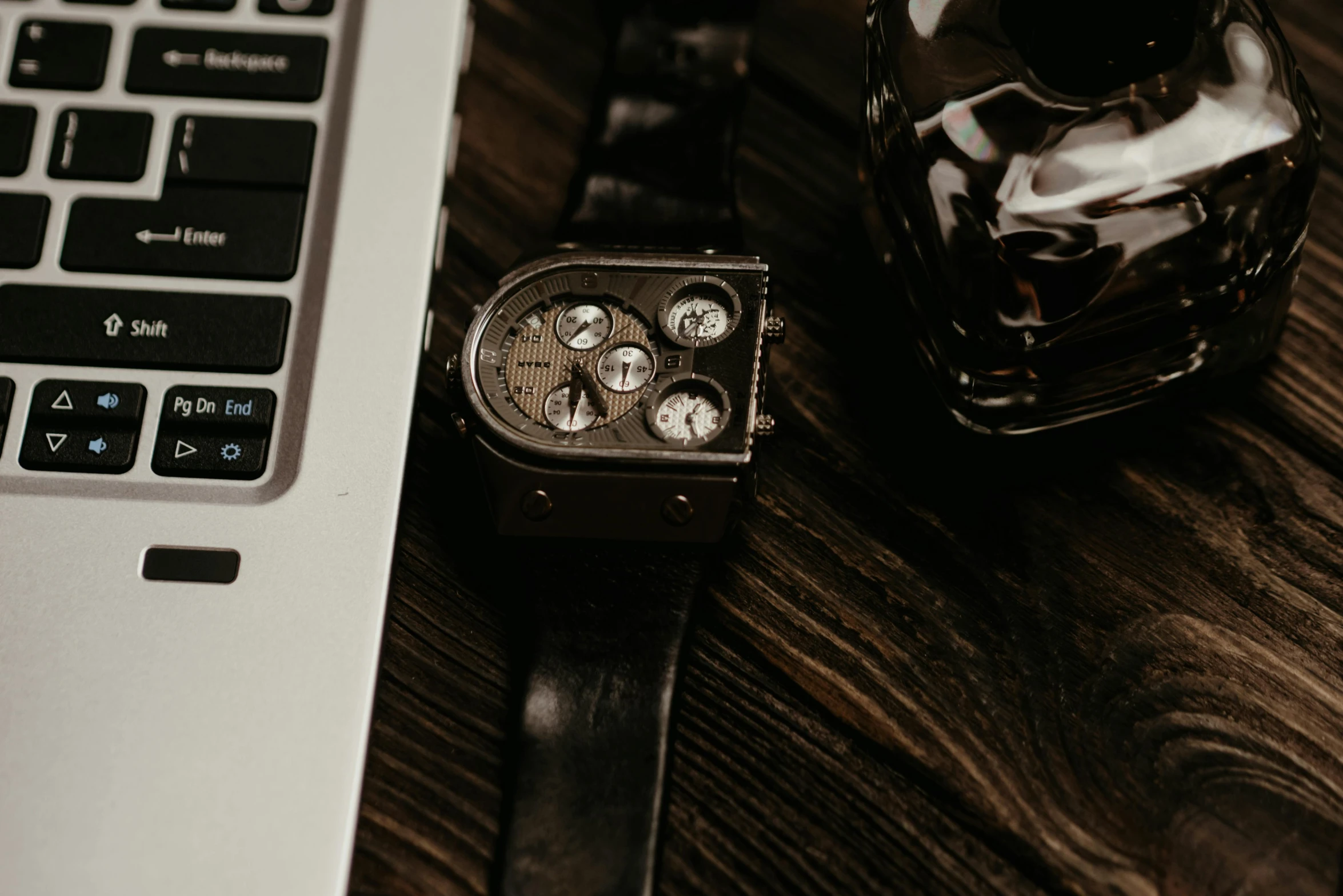 a watch sitting on top of a desk next to a keyboard