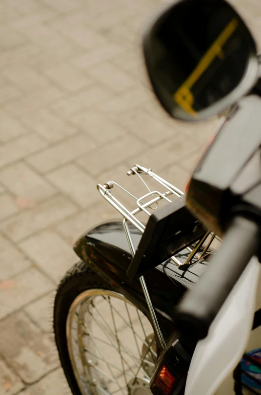 the rear end of a motor bike on a sidewalk