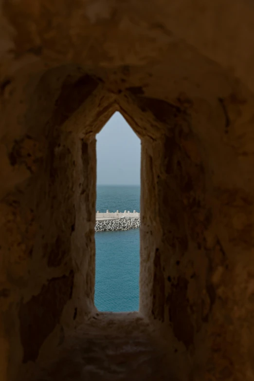 a window into the sea and beach with white rocks