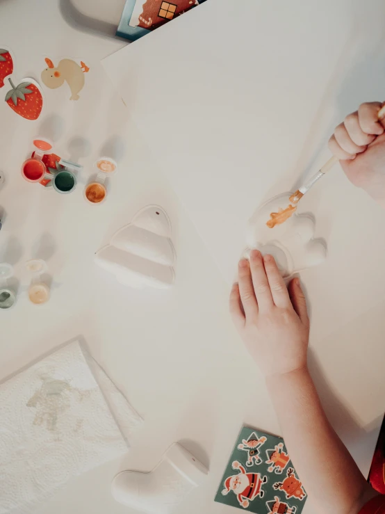 child using a spoon to make a cupcake with decorations